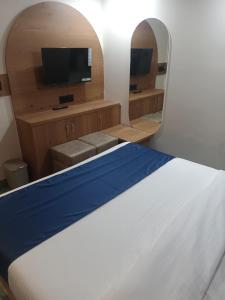 Habitación con cama y TV de pantalla plana. en hotel shivkunj, en Ahmedabad