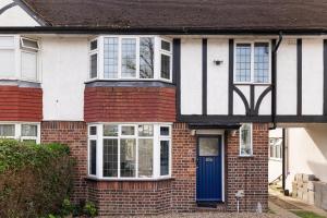 una casa in mattoni rossi con una porta blu di Livestay 3 Bed House in Hendon Private Garden&Parking a Colindale