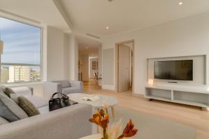 a living room with a couch and a tv at Pestana Tanger - City Center Hotel Suites & Apartments in Tangier