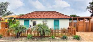 una pequeña casa con una valla delante de ella en Lorna Beach Cottage at Spanish Village, en Port Aransas