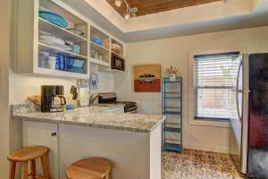 una cocina con encimera y algunas sillas. en Lorna Beach Cottage at Spanish Village, en Port Aransas
