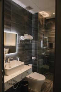 a bathroom with a toilet and a sink and a shower at MELA HOTEL in Mỹ Thạch