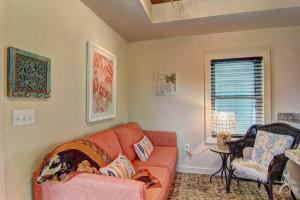 Una sala de estar con un sofá rojo y una ventana. en Lorna Beach Cottage at Spanish Village, en Port Aransas
