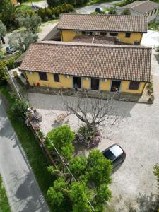 una casa amarilla con un coche aparcado delante de ella en Le Casette in Collina en Cerveteri