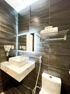 ein Badezimmer mit einem weißen Waschbecken und einem WC in der Unterkunft MELA HOTEL in Mỹ Thạch