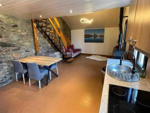 uma cozinha e sala de jantar com uma mesa e uma parede de pedra em Appartement Duplex entre Genève et Lausanne em Saint-Livres