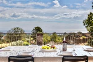 a table with a bowl of fruit and a bottle of wine at Villa MELANY Casa Vacanza in Piedimonte Etneo +50 photos