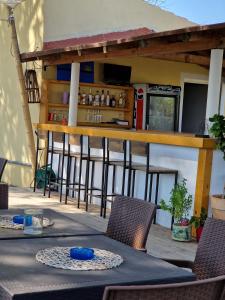 a table and chairs on a patio with a bar at Alexandra Studio 6 in Lefkímmi