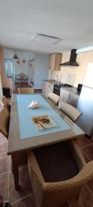 a dining room table with chairs and a kitchen at Casa Isleta in La Manga del Mar Menor