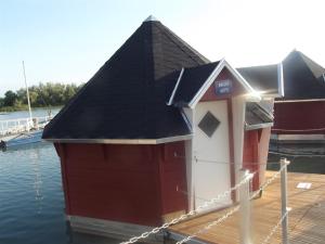 ein kleines Haus auf einer Anlegestelle im Wasser in der Unterkunft Maritime Freizeit Camp "MFC" Erfurter Seen in Stotternheim