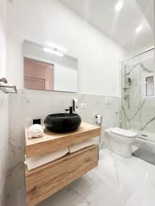 uma casa de banho com um lavatório preto e um WC. em A few steps from the port of Nervi em Gênova