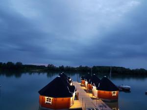 eine Reihe von Hütten auf einem Dock im Wasser in der Unterkunft Maritime Freizeit Camp "MFC" Erfurter Seen in Stotternheim