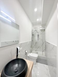 uma casa de banho com um lavatório preto e um WC. em A few steps from the port of Nervi em Gênova