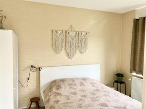 een slaapkamer met een bed en een muur bij NEW: Summerhouse near beach&lake in Noordwijkerhout