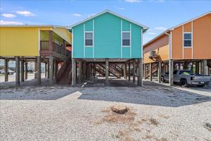 a row of houses on stilts in a parking lot at Blue Marlin Cottage (Anchor Courts #3) in Port Aransas