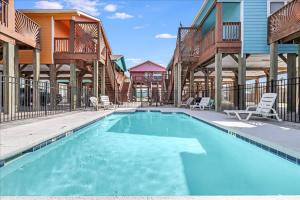 a swimming pool with chairs and a resort at Blue Marlin Cottage (Anchor Courts #3) in Port Aransas