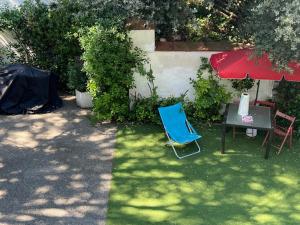 einen blauen Stuhl, einen Tisch und einen roten Regenschirm in der Unterkunft Alojamiento privado en casa de montaña in Matadepera