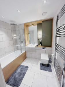 a bathroom with a tub and a toilet and a sink at Charming 1-Bed Apartment in London in London