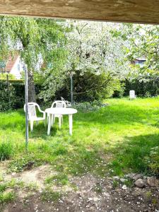 uma mesa branca e duas cadeiras num quintal em Messe 3 Minutes em Hanôver