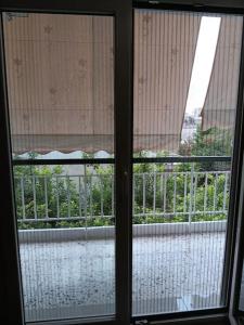ein Fenster mit Blick auf den Regen im Freien in der Unterkunft Ilion apartments in Athen