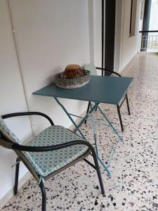 einen Tisch und einen Stuhl mit einer Schüssel Essen drauf in der Unterkunft Ilion apartments in Athen