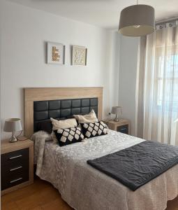a bedroom with a large bed with pillows on it at APARTAMENTO APARTACLUB REFORMADO in Chiclana de la Frontera