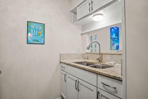 a kitchen with white cabinets and a sink at Fish Station Bike Rack BBQ Golf Cart Access in Port Aransas +11 photos
