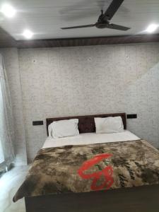 govind resort في نويدا الكبرى: سرير في غرفة نوم مع مروحة سقف