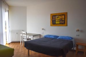 Ciceri Properties Monte Zeda في فيربانيا: غرفة نوم بسرير وطاولة مع كرسي