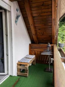 un porche con un banco y una mesa en una casa en Gamlitz - Eckberg, en Gamlitz