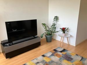 a living room with a flat screen tv on a entertainment center at Sol da Caparica in Costa da Caparica