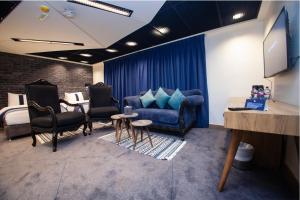 ein Wohnzimmer mit einer blauen Couch und einem Bett in der Unterkunft Monarch Hotel Amman in Amman