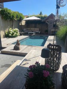 a swimming pool with a statue and flowers in a yard at B&B Grain de Sable in Knokke-Heist