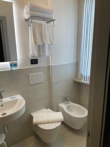 a bathroom with a toilet and a sink at Hotel Villa Rosa in Sirmione