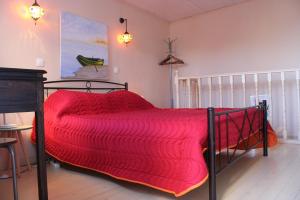 a bed with a red comforter in a room at Artistic Sea View House in Corfu