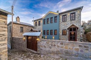 una vista exterior de una casa con una pared de piedra en Dandy Villas Nymfaio - Snow Queen - Sauna - Fireplace - Up to 6 adults 2kids, en Nymfaio