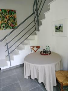 een witte kamer met een tafel en een trap bij Les Mulotières in Olivet