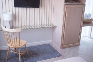 a wooden chair sitting in a room with a television at Shanti-Retreat Hotel in Pua