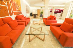 um átrio com sofás laranja e uma mesa em Hotel Atlantic by Hoteles Centric em Es Cana