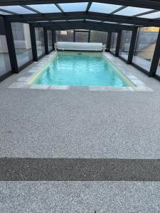 een zwembad in een gebouw met een glazen plafond bij Villa avec piscine à Mende capacité 12 personnes in Mende