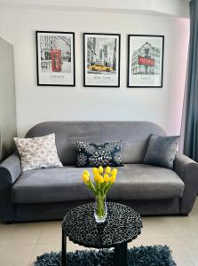 sala de estar con sofá y mesa con flores amarillas en Dream Apartment, en Split
