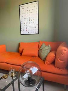 an orange couch in a living room with a table at G23 in Sarpsborg