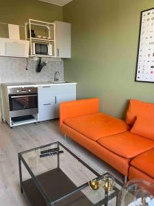 uma sala de estar com um sofá laranja e uma mesa em G23 em Sarpsborg