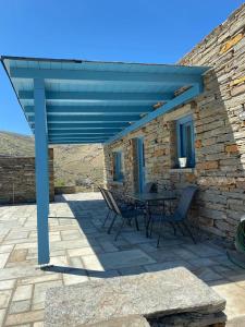 eine Terrasse mit einer blauen Pergola sowie einem Tisch und Stühlen in der Unterkunft SEAVIEW UP in Korissia