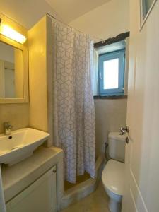 uma casa de banho com um lavatório e um WC com uma cortina de chuveiro em SEAVIEW UP em Korissia