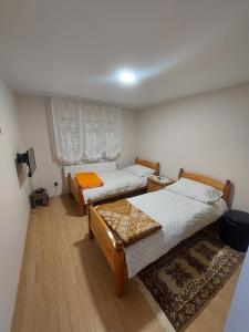 a bedroom with two beds and a rug at Vila Pavle in Užice