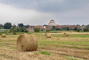 a field with hay bales in front of a city at 4 TEA 4 HOUSE in Romano Canavese