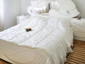 un letto bianco con un mazzo di fiori sopra di Charming villa in Umag with private pool a Umag (Umago) Altre 18 foto