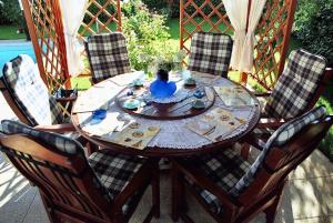 una mesa de madera con sillas y un jarrón azul. en 3 bedrooms villa with private pool enclosed garden and wifi at Umag 1 km away from the beach, en Umag