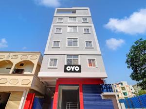 a tall white building with an ovy sign on it at Flagship Hotel Shannu Grand in Hyderabad